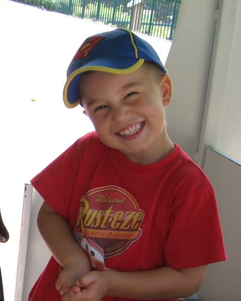 Hugo Fleury enfant, en t-shirt Rust-eze et casquette Flash McQueen